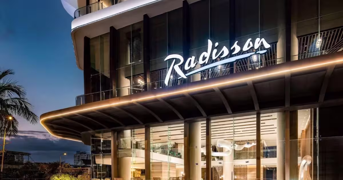 Illuminated Radisson sign above the entrance of a modern hotel at dusk